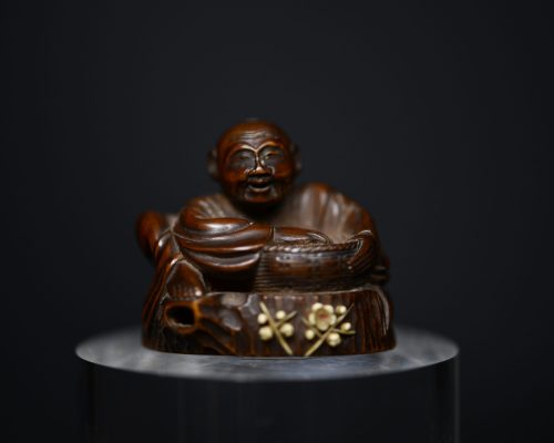 Netsuke man on stump wood