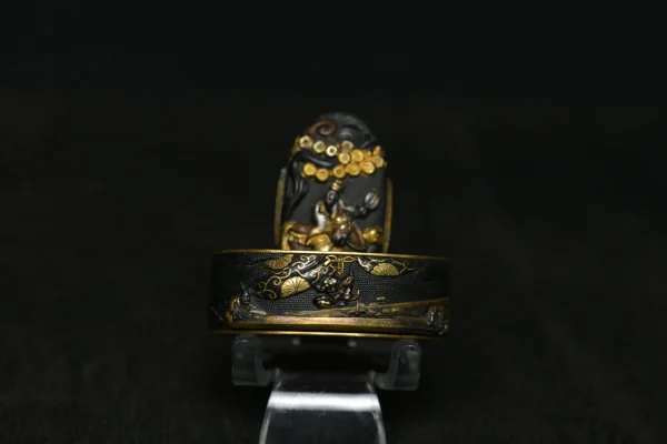 Fuchi Kashira in shakudō con scena di carpentieri